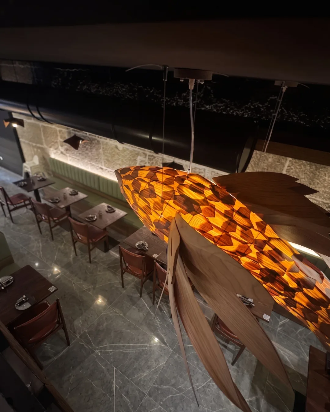 Sala do restaurante vista de cima, com o candeeiro em forma de peixe